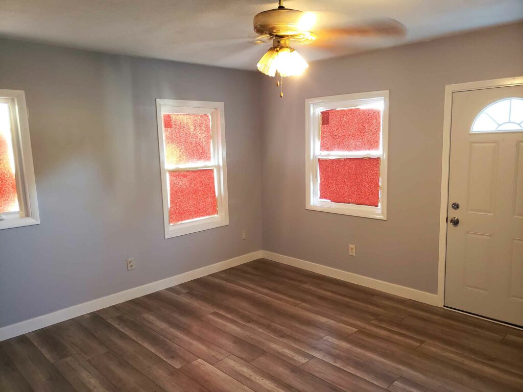 An empty living room with paper on the windows.