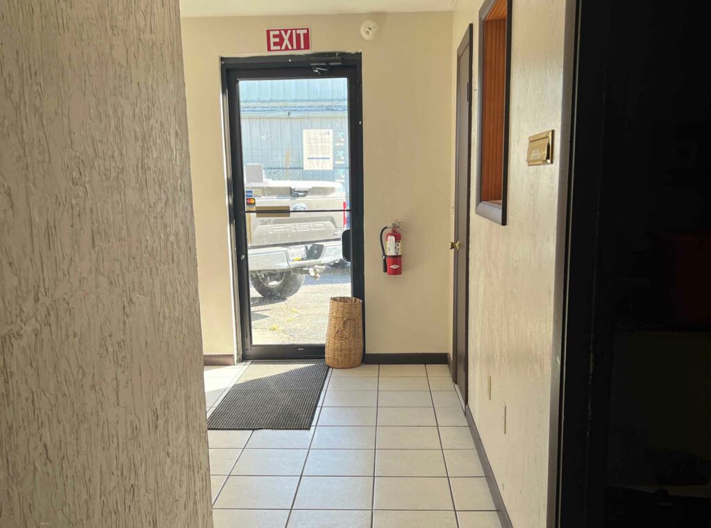 Exit door with a fire extinguisher at KO Storage's commercial office space in Keystone Heights, FL.