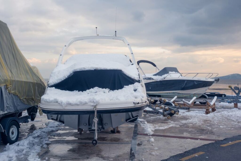 Snow landing on a boat outside covered in a