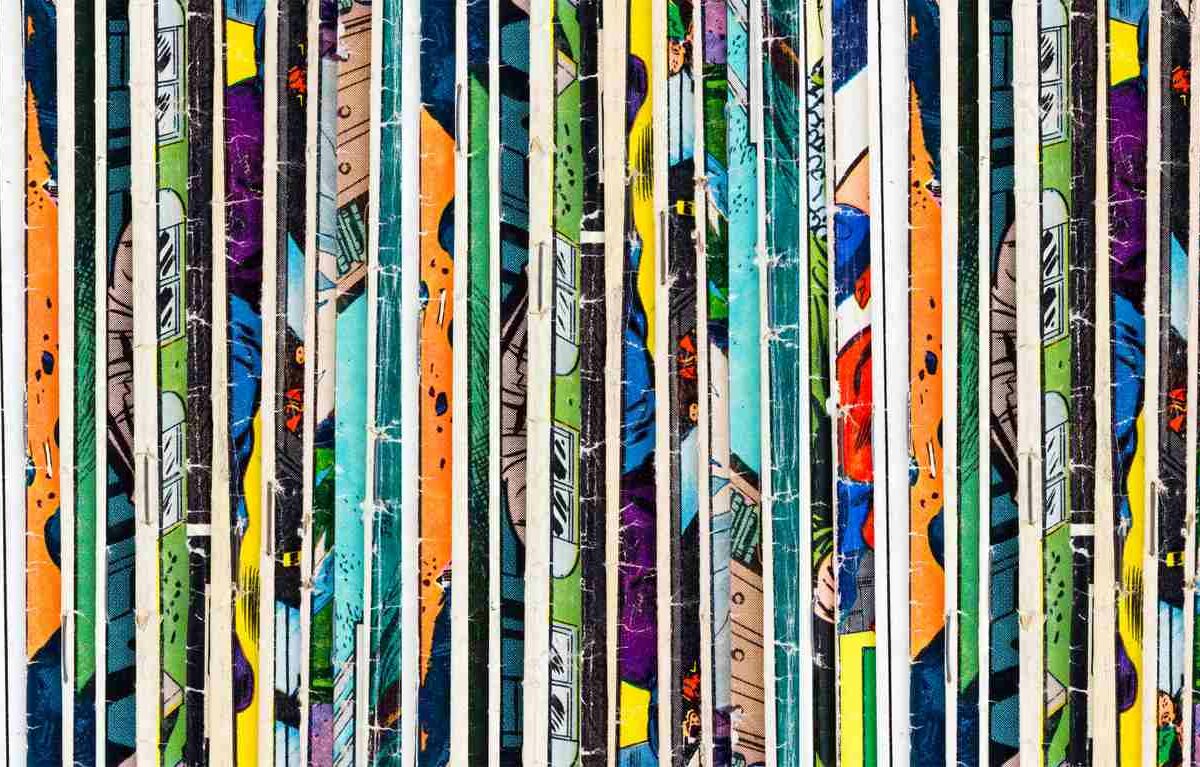 : A row of colorful comic books as part of a collection on a shelf.