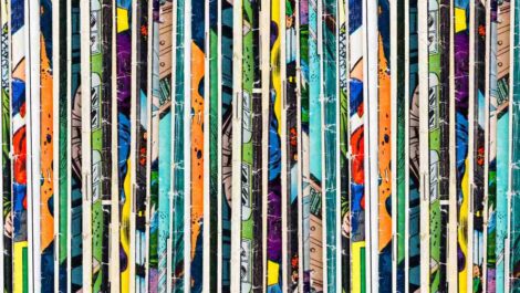 : A row of colorful comic books as part of a collection on a shelf.