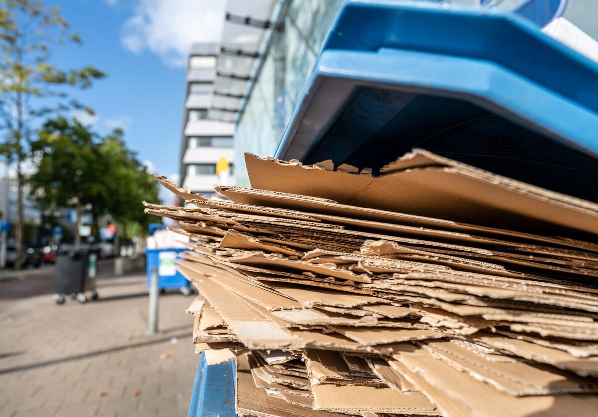 A pile of cardboard boxes recycled in a recycling bin.