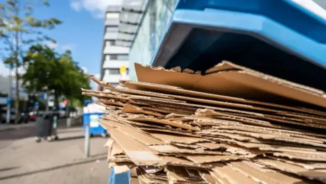 A pile of cardboard boxes recycled in a recycling bin.