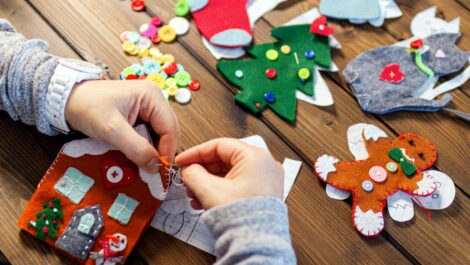 A woman makes DIY holiday decorations out of craft supplies.