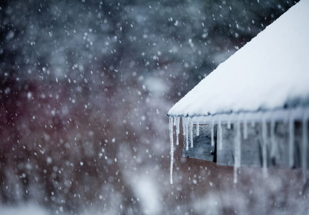 Ice freezes over a home’s gutters and roof in the middle of winter.