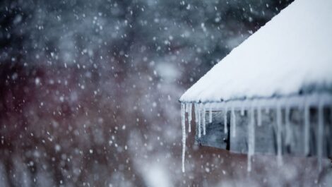 Ice freezes over a home’s gutters and roof in the middle of winter.