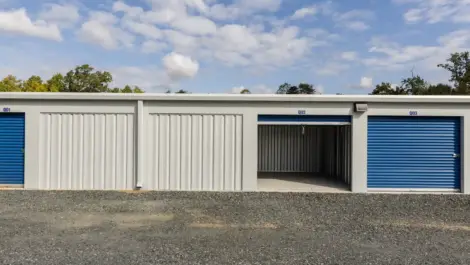 Inside view of an empty storage unit with metal walls and roll-up door.
